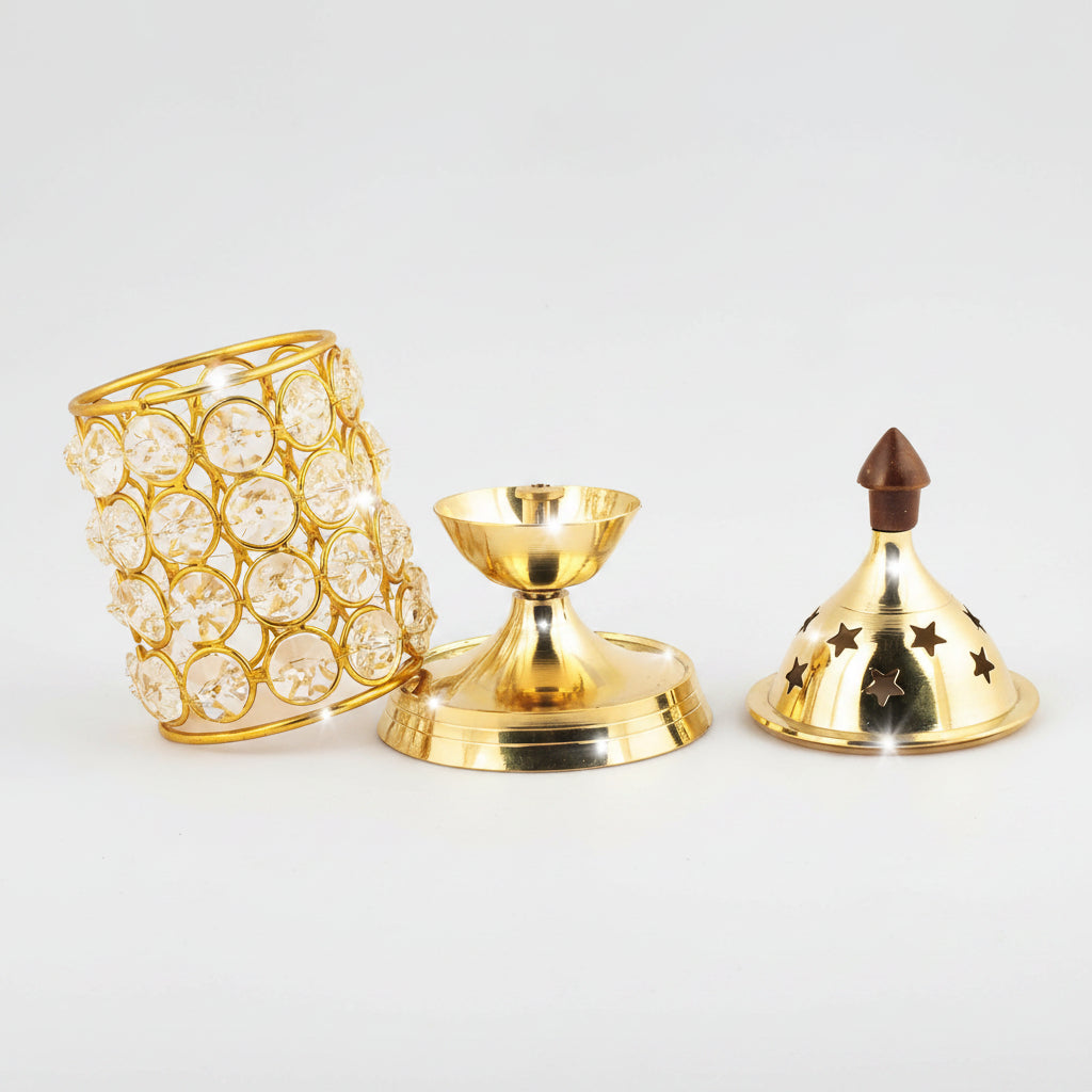 Gold brass candle holder set with a cylindrical crystal-encrusted body, a central candle cup, and a perforated lid with star cutouts, shown on a white background with text highlighting durable brass material, floral engraving, sturdy construction, and long-lasting use.